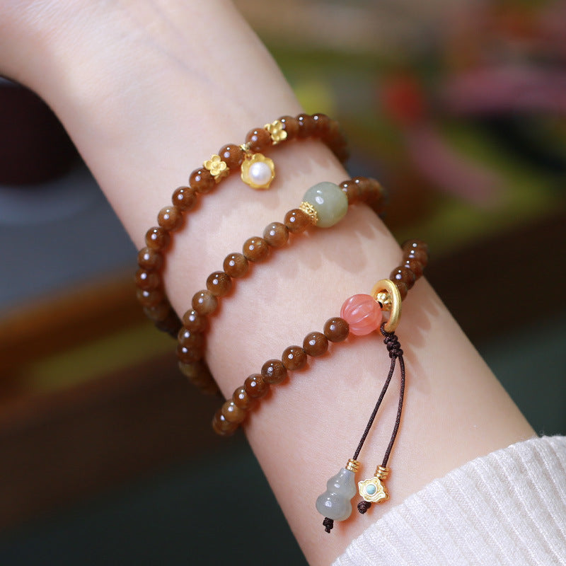 Jade Armband am Handgelenk mit braunen Perlen und farbigen Steinen getragen
