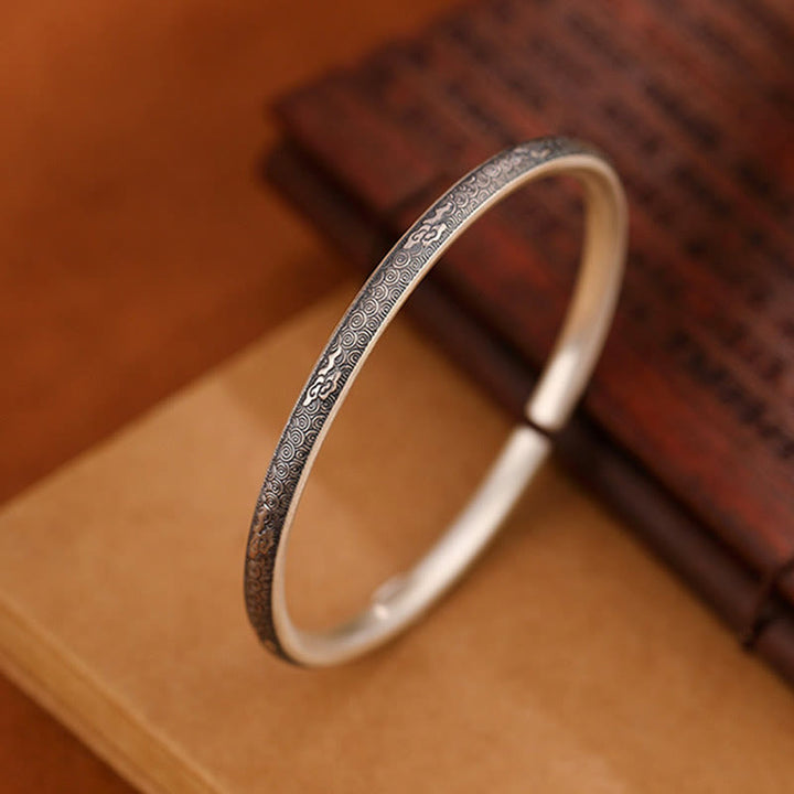 Silbernes Armband 925 mit feinem Muster auf beigem Untergrund.