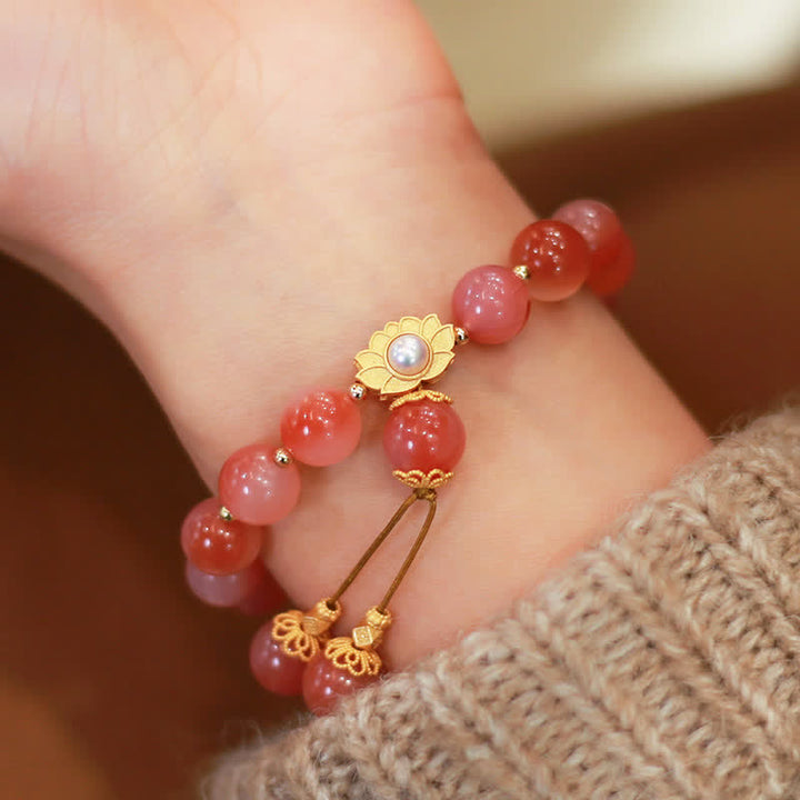 Rotes Achat Armband mit goldenem Lotus Charm am Handgelenk getragen