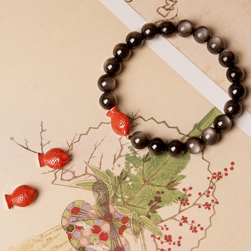 Obsidian Armband mit roten Koi Fischen Perlen auf Beige Hintergrund