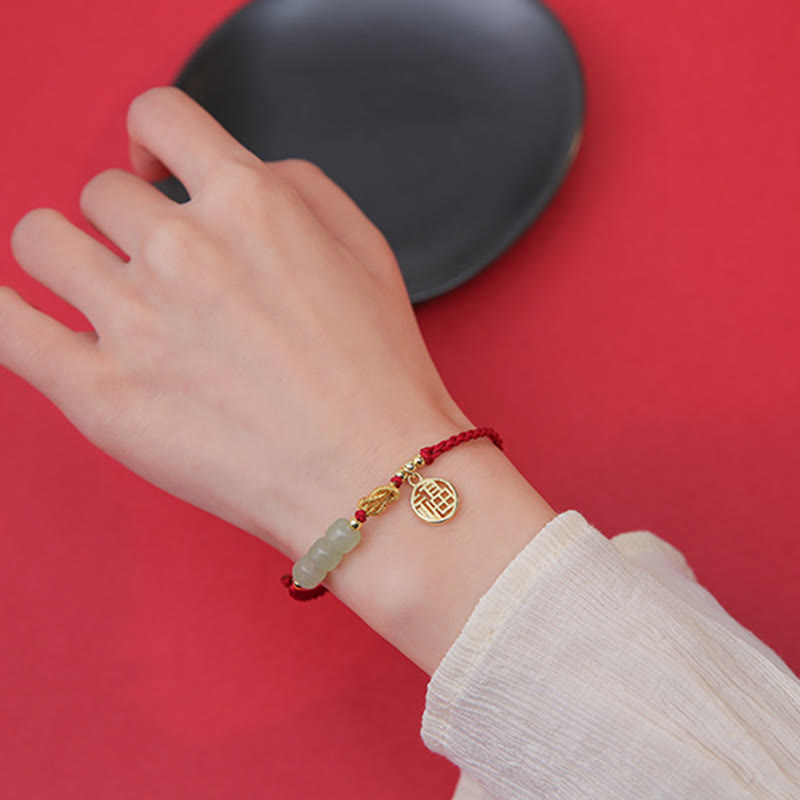 Jade Armband mit Fu-Zeichen Charm rot elastisch am Handgelenk getragen
