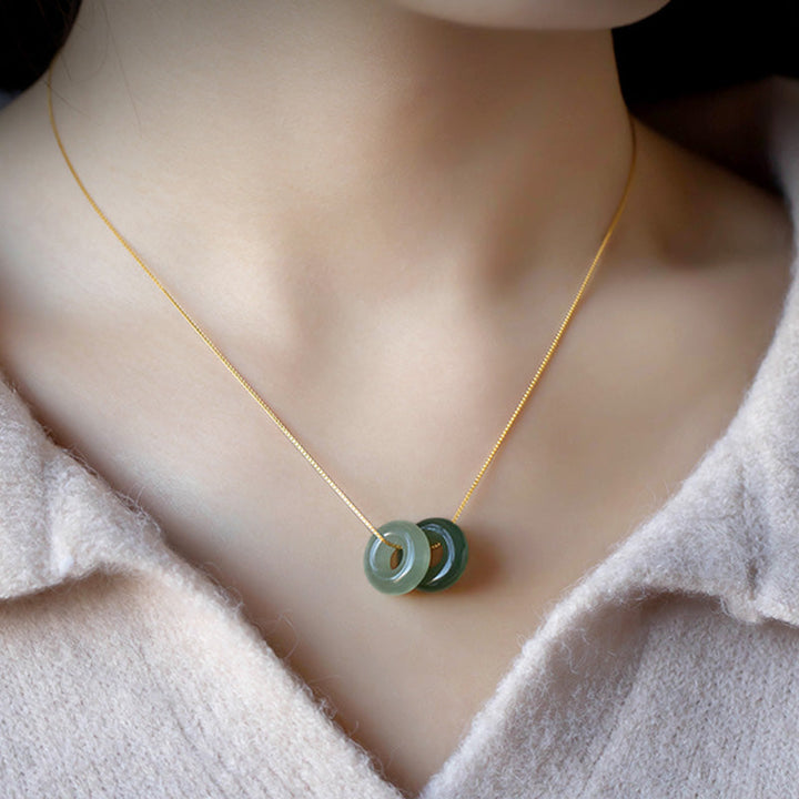 Jade Frieden Halskette mit grünen Steinen an eleganter Goldkette getragen.