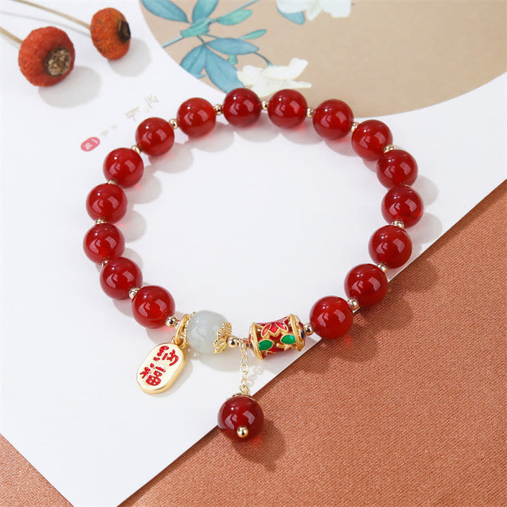 Armband Roter Achat Jade mit Segensanhänger auf weißem Hintergrund elegant präsentiert