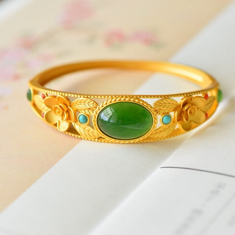 Goldenes Armband mit grüner Jade und türkisen Steinen elegant präsentiert.