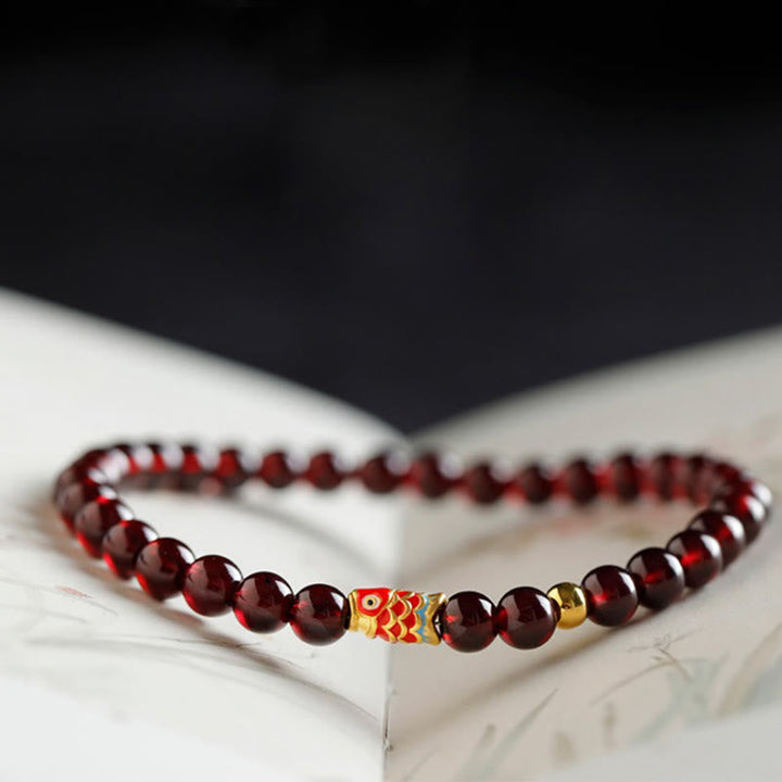 Armband Granat Koi Fisch – Schutz rote Perlen goldene Akzente elegant