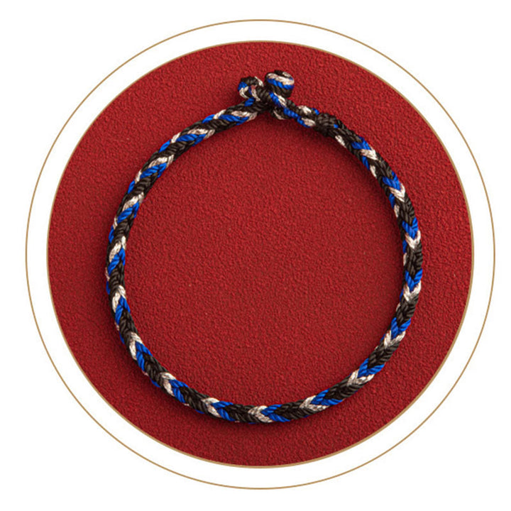Armband Mehrfarbig Glücksband Glück Wohlstand auf rotem Hintergrund Flat Lay