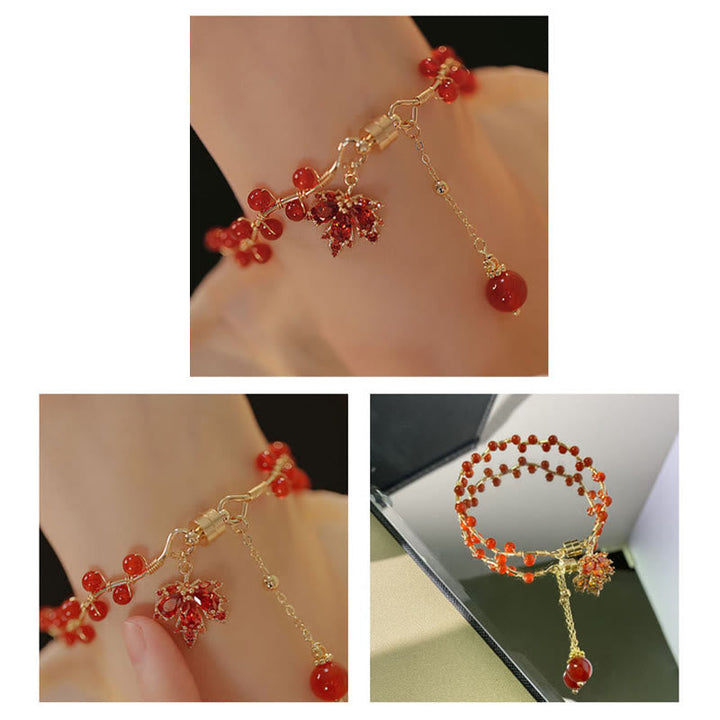 Rotes Armband mit Ahornblatt Charm am Handgelenk getragen elegant