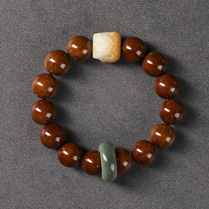 Armband mit braunen Perlen und grünem Jade-Anhänger elegant arrangiert.