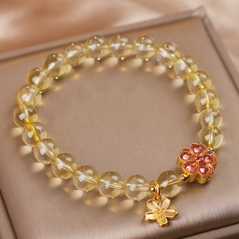 Armband Citrin mit goldenen Blüten-Charms elastisch getragen