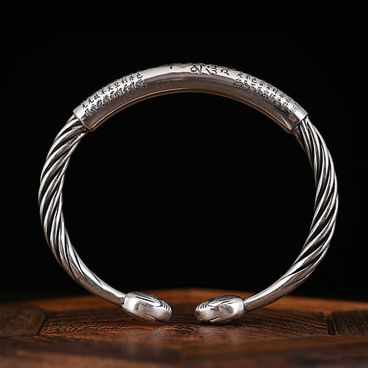 Silbernes Armband Om Mani Padme Hum Herzsutra auf Holz Nahaufnahme