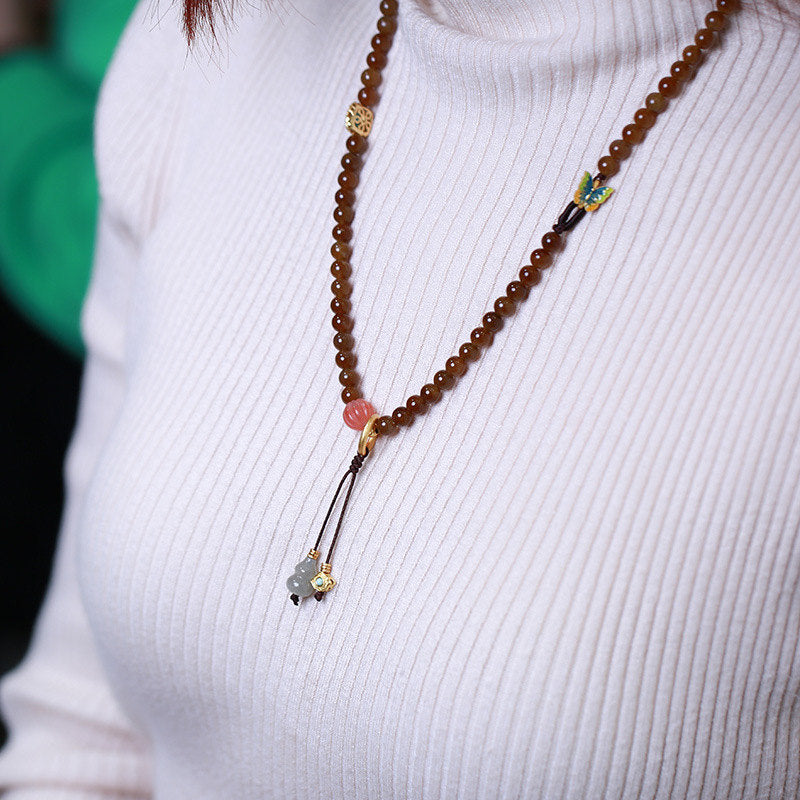 Jade Schmetterling Armband mit braunen Perlen elegant getragen.