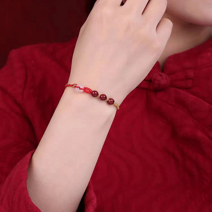 Armband Zinnober Jade am Handgelenk mit roten Perlen elastisch getragen