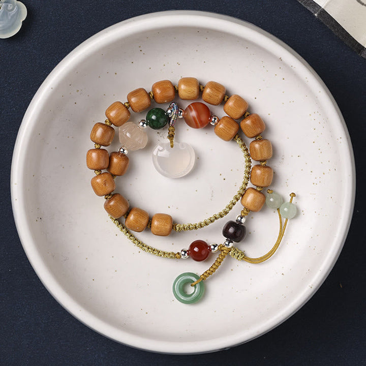 Armband Sandelholz mit bunten Steinen und Quasten-Details.