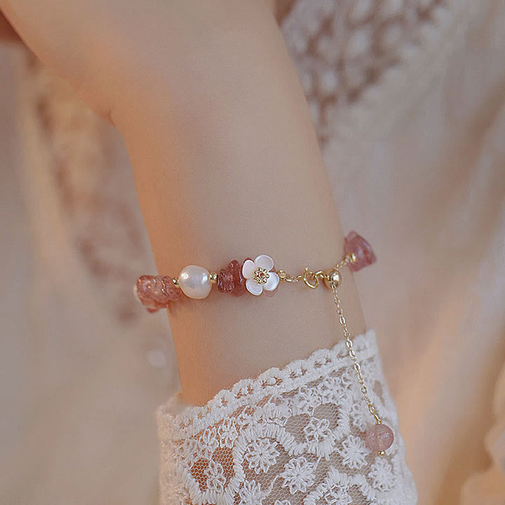 Armband Erdbeerquarz Perle Blume Heilung am Handgelenk mit Spitzenkleid getragen