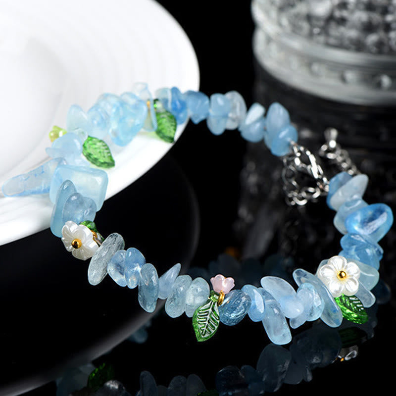 Armband Erdbeerquarz Aquamarin mit Blüten und Blättern dekoriert am Handgelenk