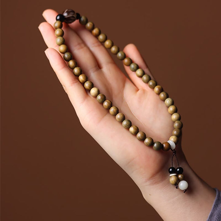 Armband Sandelholz Bodhi Lotus am Handgelenk mit braunen Perlen getragen