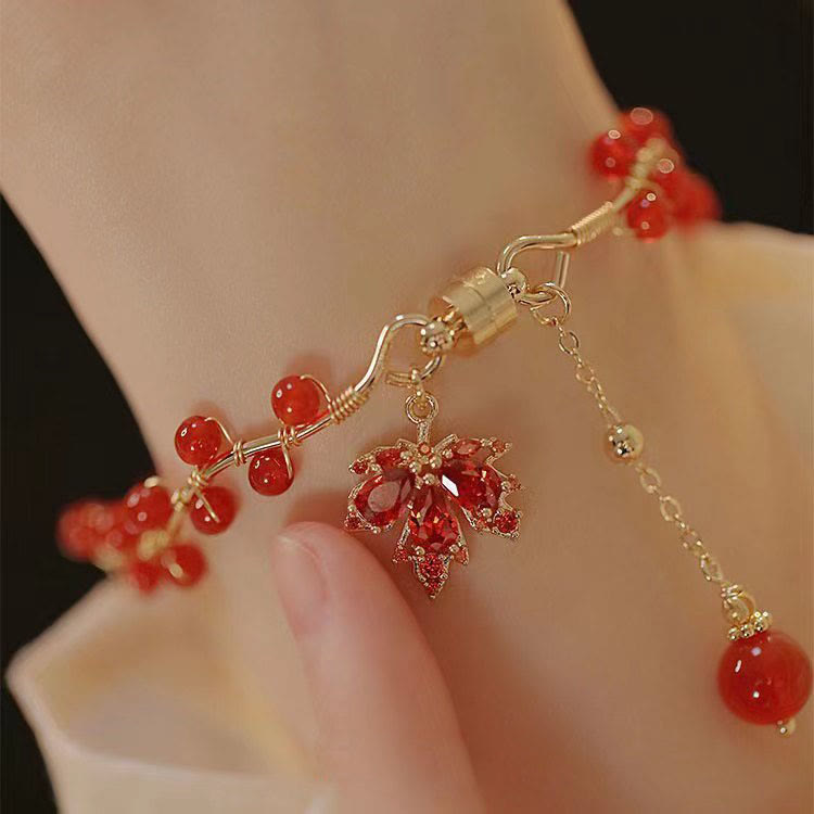 Rotes Ahornblatt Armband mit Perlen elegant am Handgelenk getragen