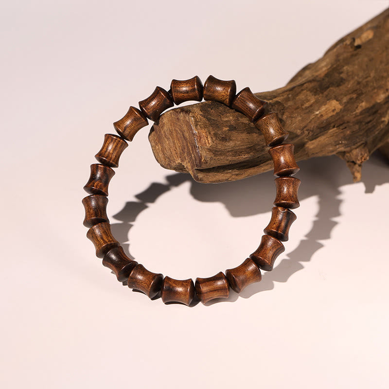 Armband Rosenholz Fu-Zeichen mit Holzperlen auf Ast präsentiert
