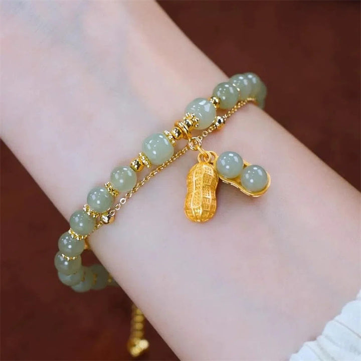 Jade Armband mit Fu-Zeichen Charm, goldene Perlen elegant am Handgelenk.