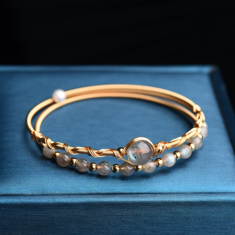 Armband Mondstein gold Perlen auf blauem Hintergrund Flachaufnahme Schmuck