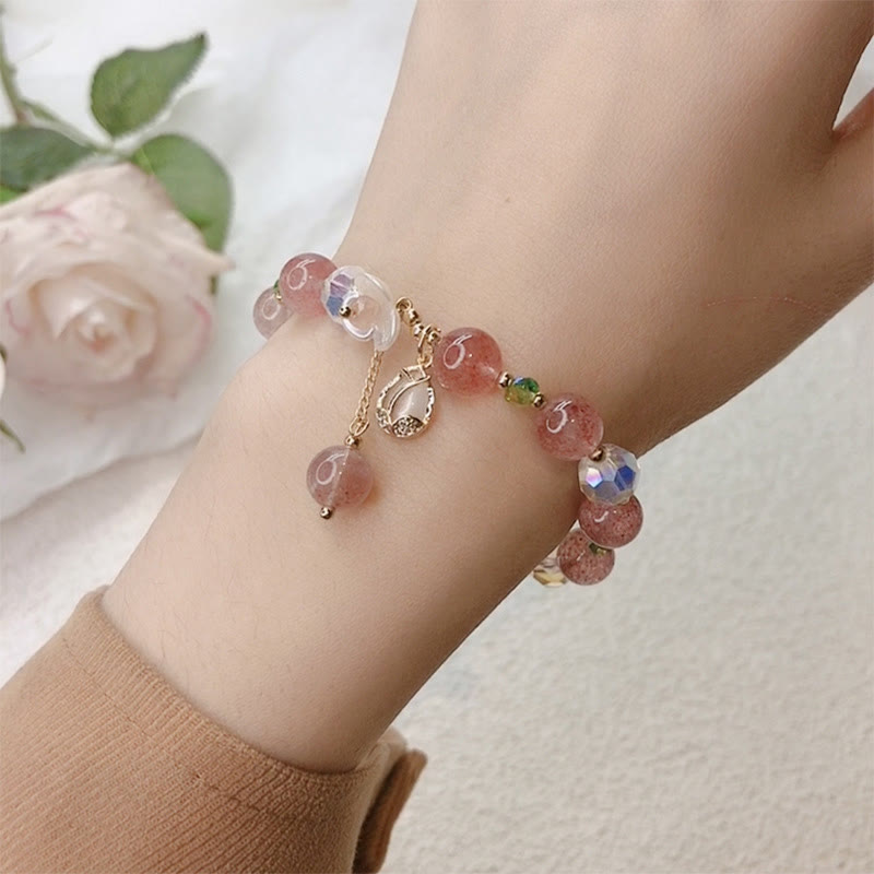 Armband Erdbeerquarz Fluorit am Handgelenk mit silbernen Elementen getragen