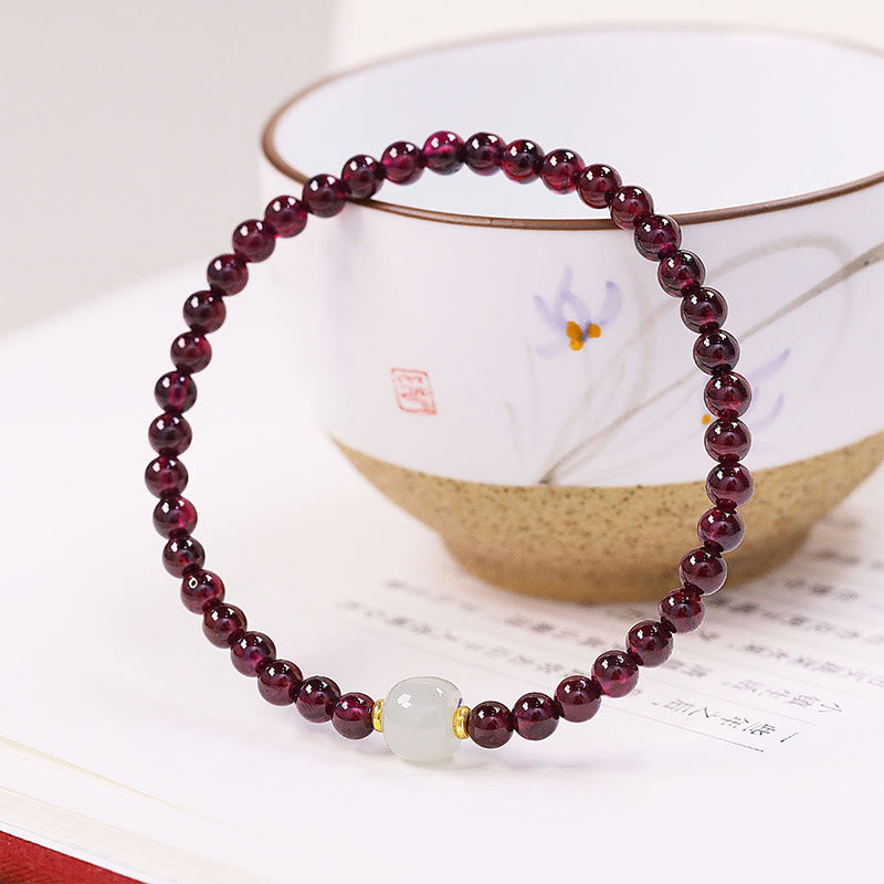 Armband Granat Jade Katze mit roten Granaten auf Flatlays mit Schale