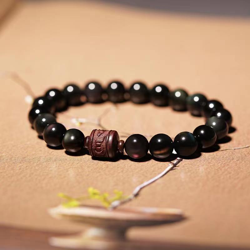 Schwarzes Obsidian Armband mit Om Symbol Perle elegant präsentiert.