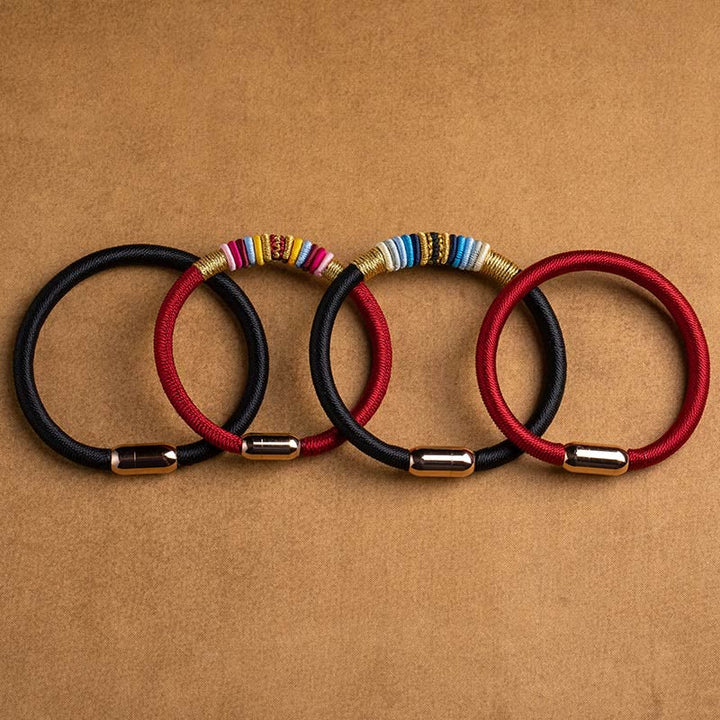 Vier magnetische Armbänder in Schwarz und Rot mit Perlenbesatz.