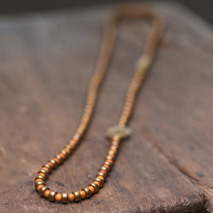 Kupfer Armband mit Perlen auf braunem Lederuntergrund elegant.