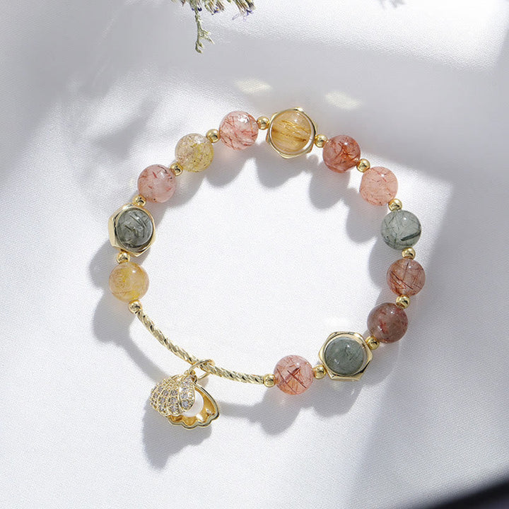 Buntes Armband mit Rutilquarz und Shell Anhänger auf weißem Hintergrund.