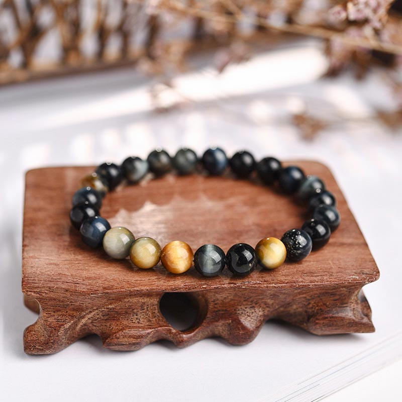 Armband Tigerauge Kristall auf Holzständer schwarze goldene Perlen Heilung