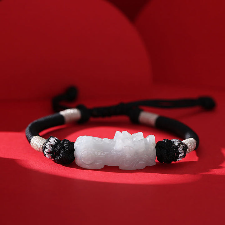 Armband Jade Pixiu mit schwarzen Perlen auf rotem Hintergrund.