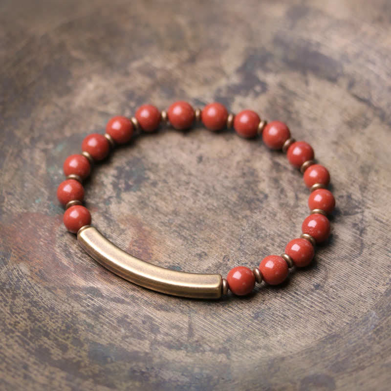 Rotes Perlenarmband mit Metallverschluss auf Holzoberfläche Nahaufnahme