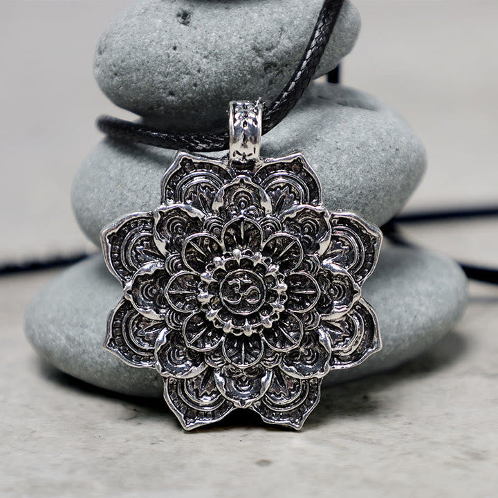 Kette Stein Lotus – Bild 2 – Silberner Lotus Mandala Anhänger an schwarzer Kette auf Steinen