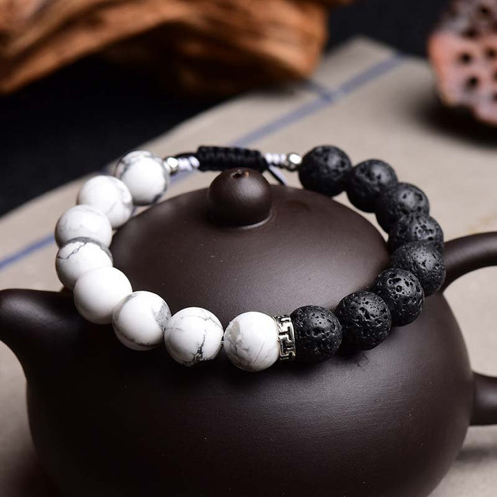 Armband Lavastein Yin Yang – Schutz auf schwarzer Teekanne, Yin Yang Design.