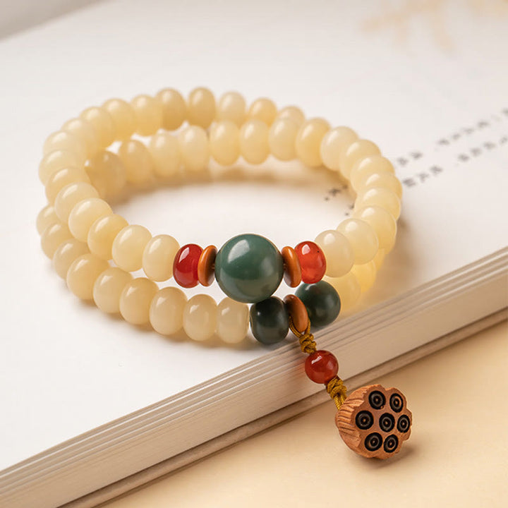 Bodhi Lotus Armband mit cremefarbenen Perlen und Anhänger elegant.