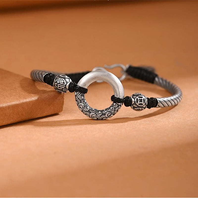 Silber Kupfer Armband mit Fu-Zeichen Glückssymbol auf braunem Untergrund