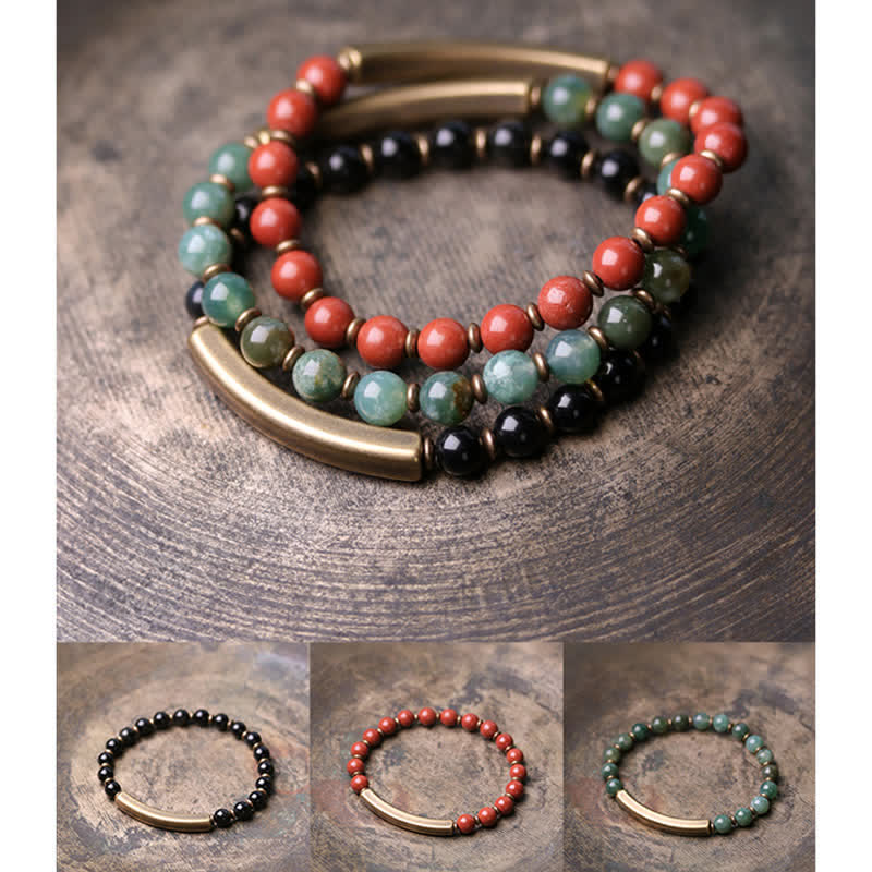 Elegante Armbänder mit Obsidian, roten und grünen Steinen, Messingakzenten Nahaufnahme.