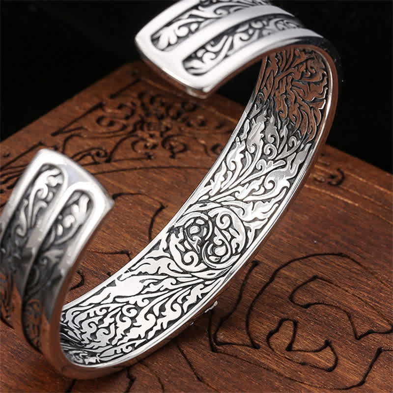 Silbernes Armband 925 mit Ornamenten auf Holzoberfläche.