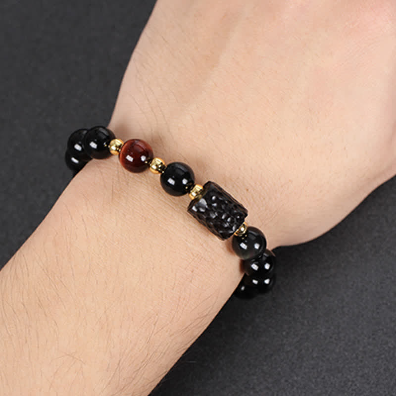 Schwarzes Obsidian Armband mit Tigerauge Perle elegant am Handgelenk getragen
