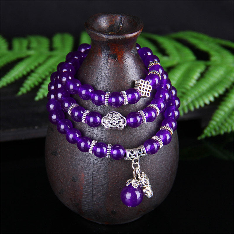 Amethyst Pixiu Armband mit silbernen Anhängern auf dunklem Hintergrund