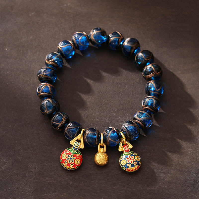 Armband mit blauen Perlen und goldenem Glückscharm Anhänger elegant.