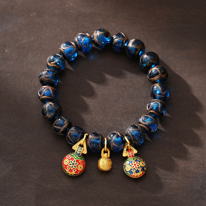 Armband mit blauen Perlen und goldenem Glückscharm Anhänger elegant.