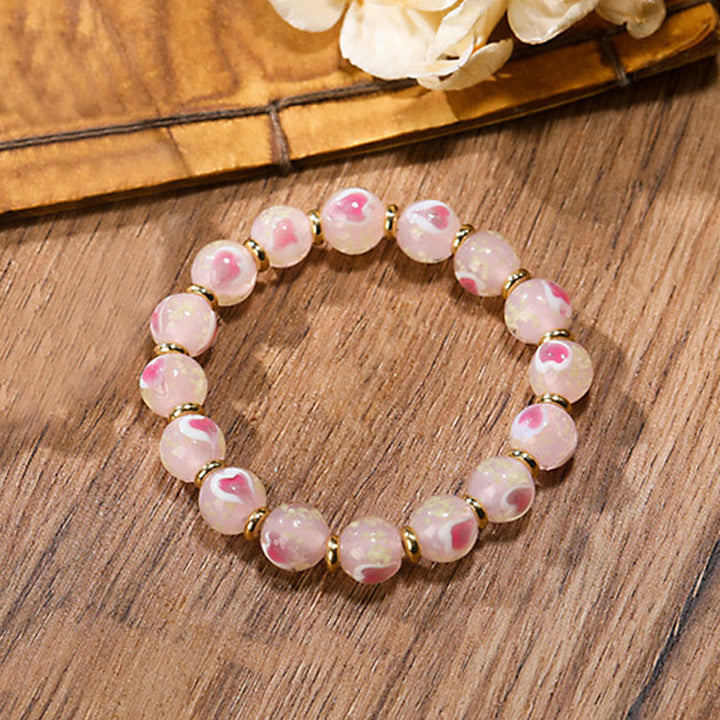 Rosenquarz Armband – Liebe & Segen mit rosa Perlen und goldenen Zwischenelementen.