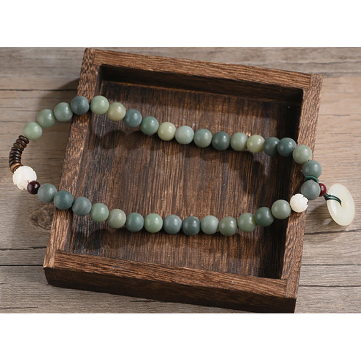 Jade Bodhi Lotus Armband mit grünen Perlen und Accessoires elegantly displayed