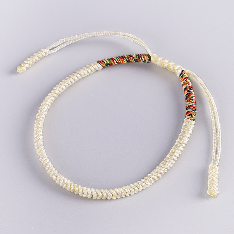 Tibetisches Armband mit buntem Glücksfaden auf neutralem Hintergrund elastisch.