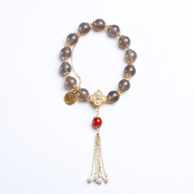 Armband mit grauen Achat Perlen, Fuxzeichen und roter Achat Quaste.