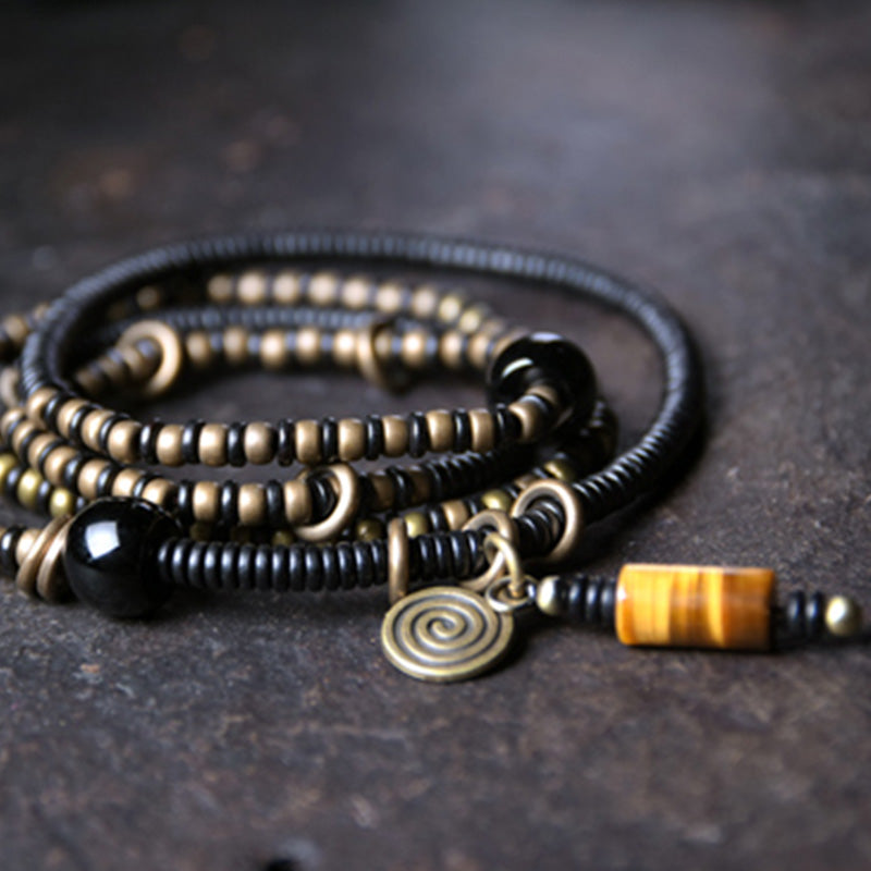 Schwarzes Armband Kupfer Ebenholz mit Spiralanhänger elegant getragen