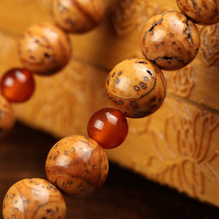 Armband Tibet Bodhi Samen Weisheit Nahaufnahme braune Holzperlen rote Achatperle
