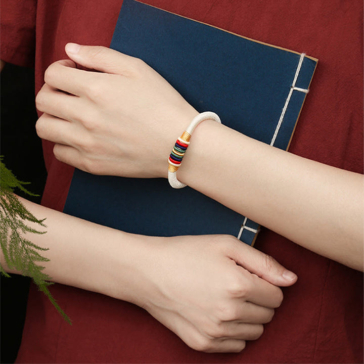 Armband Fünf Elemente am Handgelenk mit bunten Perlen und weißem Stein
